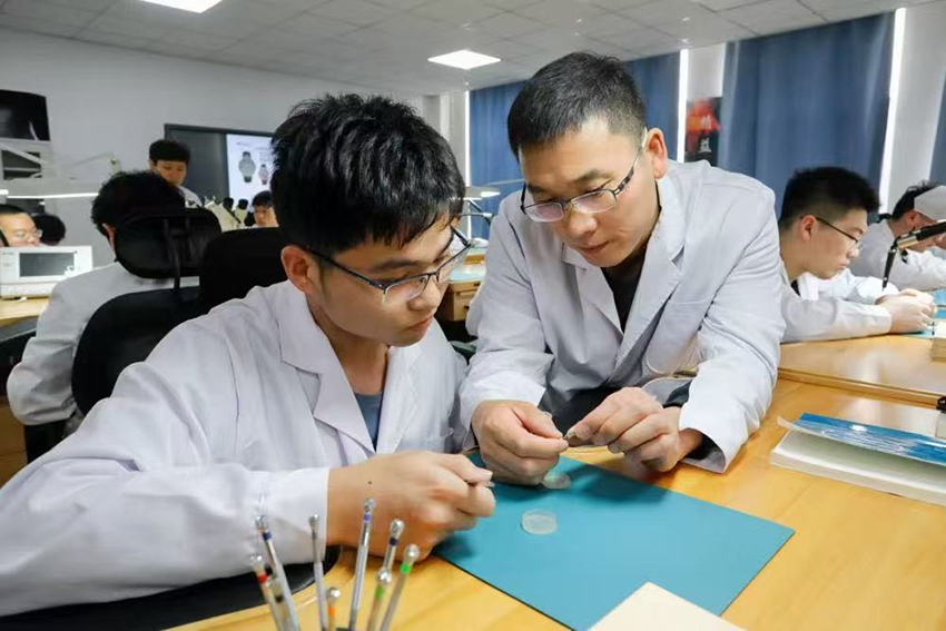 师生共同分析已装配完成的计时机芯工作状态。金年会jinnianhuicom供图